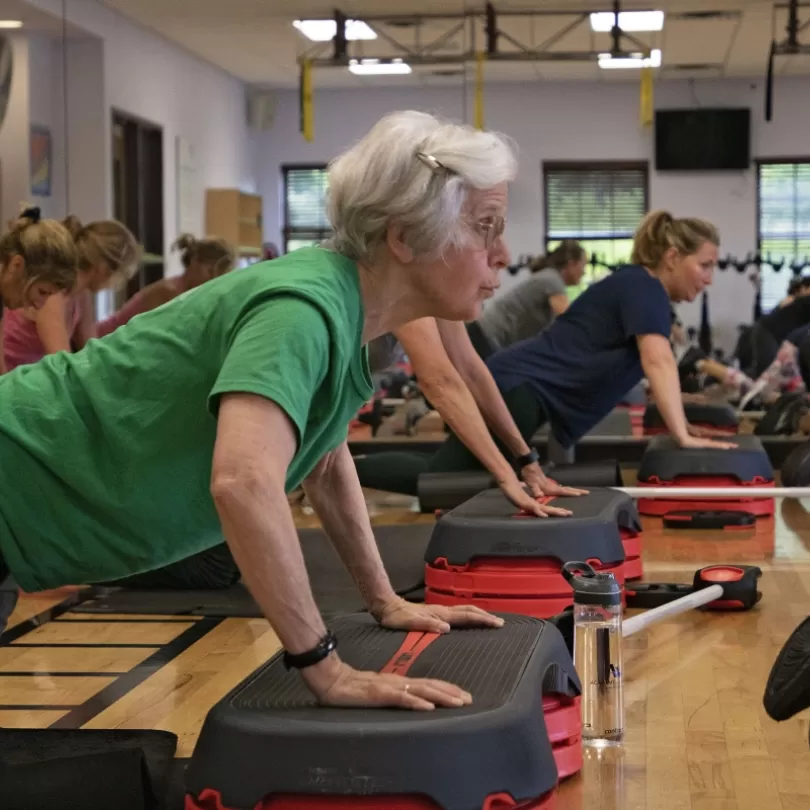 HIIT class woman doing pushup on stepper 