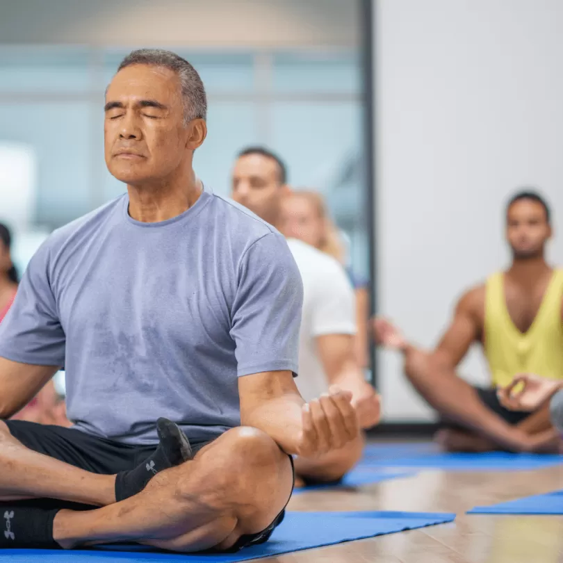 Elderly man in group yoga class.