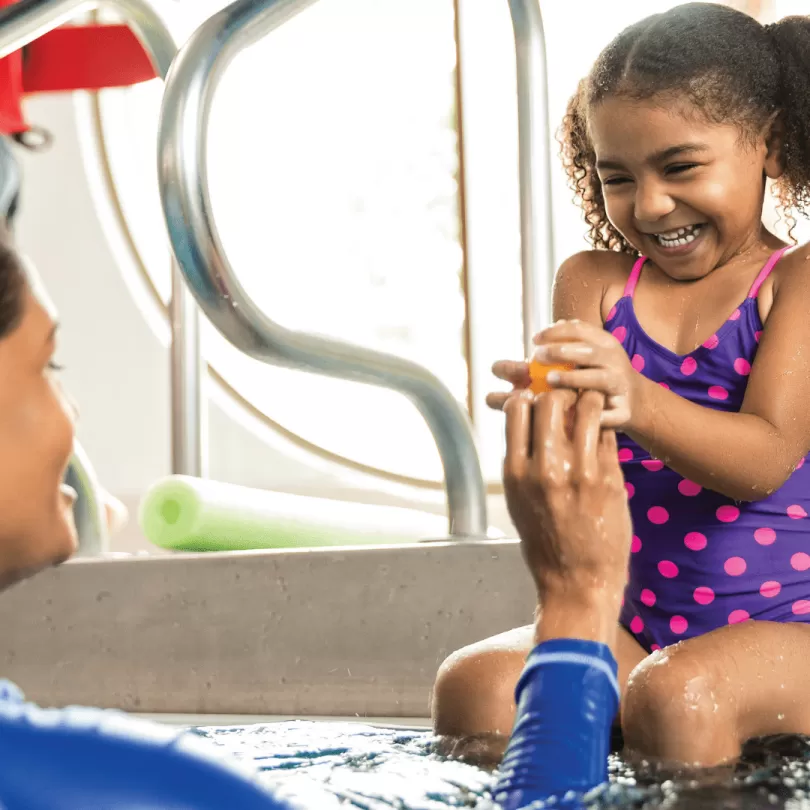 A little girl in pool during swim lessons.