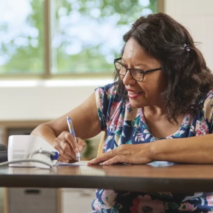 Woman taking notes from program.