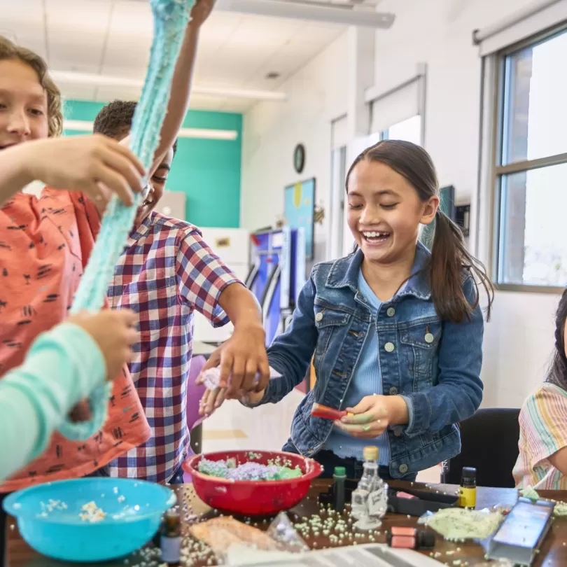 A group of kids appear to be making gak or play dough. 