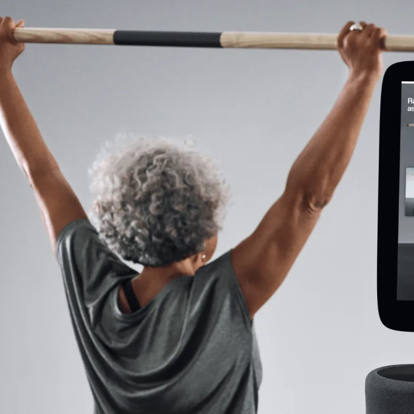 An older woman uses EGYM equipment to work out.