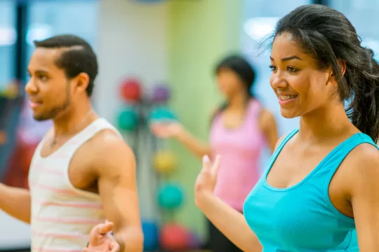 Two dancers smile as they participate in dance class.