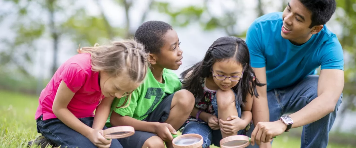 A summer day camp counselor with children