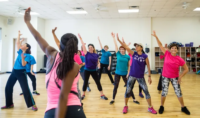 An instructor leads a dance group exercise class at the gym.