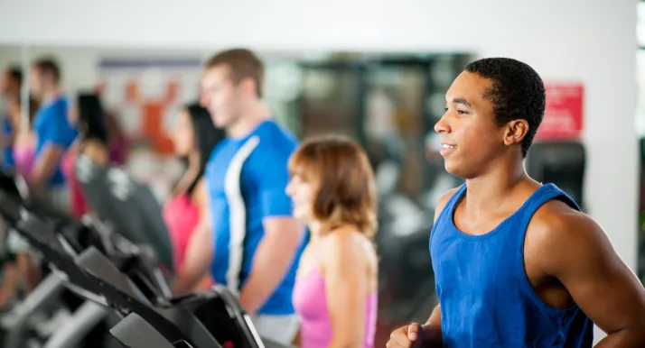 A man exercising on treadmill in a gym.