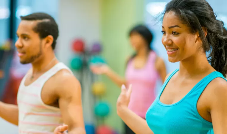 Two dancers smile as they participate in dance class.